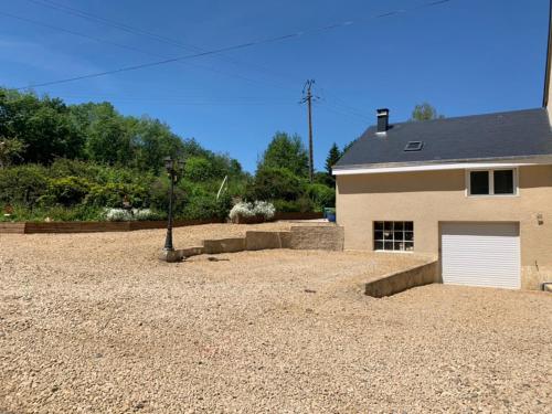 a house with a garage and a gravel yard at Le moulin 