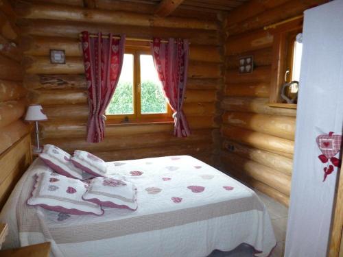 ein Schlafzimmer mit einem Bett in einem Blockhaus in der Unterkunft La fuste ardennaise in Haybes