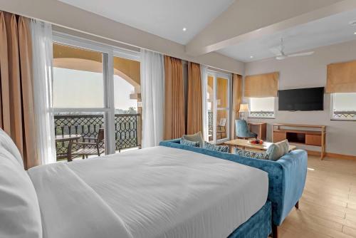um quarto com uma cama grande e uma varanda em Fairfield by Marriott Goa Calangute em Calangute