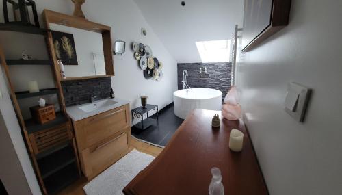 a bathroom with a sink and a bath tub at Les hauts Brianço in Solignac