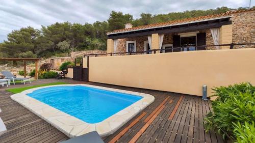 una casa con piscina en una terraza de madera en Can Pep de San Plana, en Sant Josep de sa Talaia