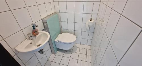 małą łazienkę z toaletą i umywalką w obiekcie City Apartment Cologne-Weiden w Kolonii