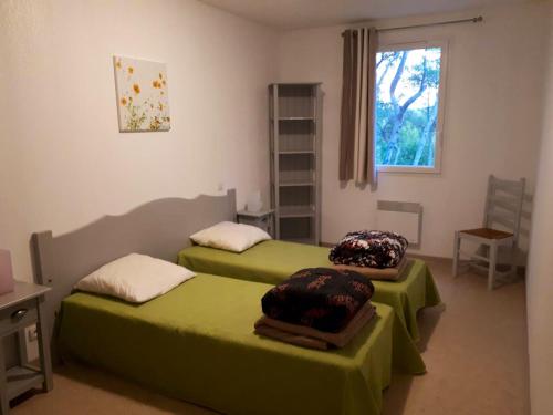 - 2 lits verts dans une chambre avec fenêtre dans l'établissement Maison conviviale à Aubignan avec piscine partagée, à Aubignan