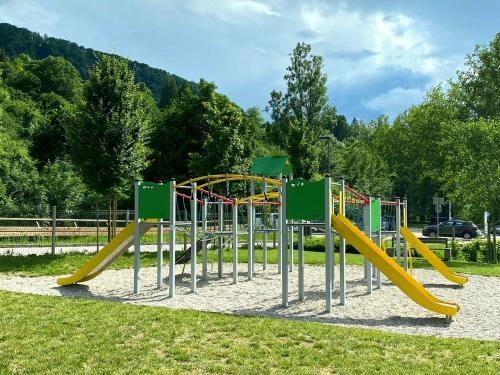 a playground with a slide in a park at Apartment Loyd, Tolmin - Most na Soči in Most na Soči