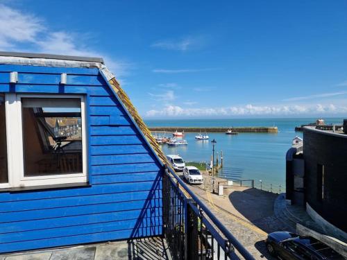 a blue building with a view of a body of water at Unique 2BD Apartment Folkestone Harbour in Kent