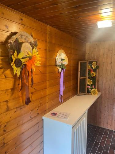a room with a wooden wall with flowers and hats at Der Kristall by Globalimmoservice in Bad Kleinkirchheim