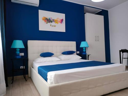 ein blaues Schlafzimmer mit einem weißen Bett mit blauen Wänden in der Unterkunft The 6th Floor in Rom