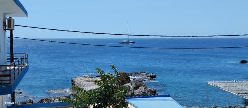 a view of the ocean with a boat in the water at Klima Rooms in Palaiochóra