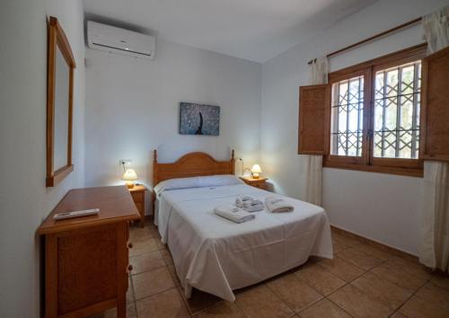 sypialnia z łóżkiem, 2 stołami i 2 oknami w obiekcie Casa Toril Cabo de Gata w mieście El Pozo de los Frailes