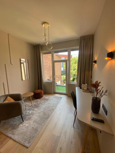 a living room with a desk and a couch and a window at Good Mood - chambres et suite in Namur