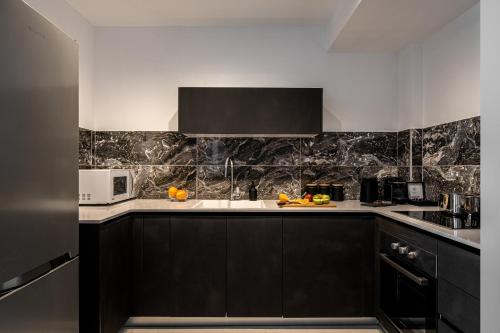 a kitchen with black cabinets and white counter tops at MACHNE YEHUDA - Exclusive Collection - By HOMY in Jerusalem