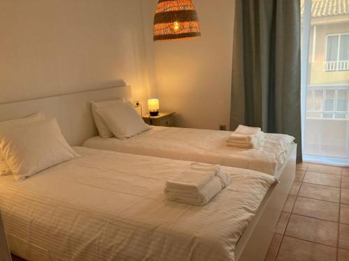 two beds in a hotel room with towels on them at Bella vista in Corralejo