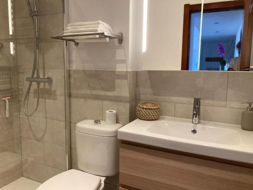 a bathroom with a toilet and a sink and a shower at Bella vista in Corralejo