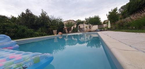 a swimming pool with blue water in front of a house at 1832 La Rabassière in Malaucène