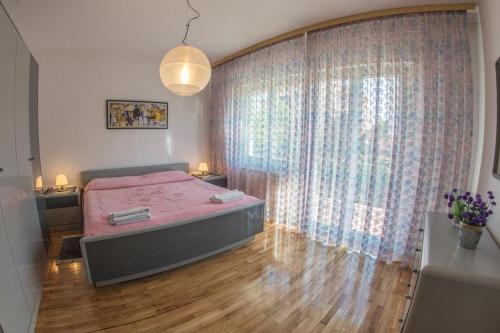 - une chambre avec un lit rose et une grande fenêtre dans l'établissement Apartment in Banjole with balcony, air conditioning, WiFi 4211-1, à Banjole