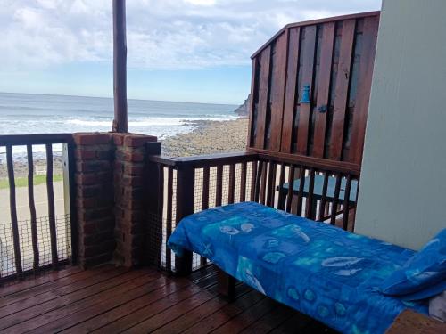 a bench on a balcony with a view of the beach at Sea Shell in Morganʼs Bay