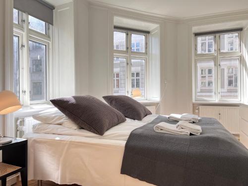 - une chambre blanche avec un lit doté d'oreillers et de fenêtres dans l'établissement Apartment Located In Cozy Area Of Copenhagen 2, à Copenhague