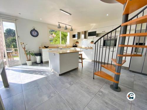 une cuisine et un salon avec un escalier dans une maison dans l'établissement MAGNIFIQUE VILLA PISCINE PROCHE NICE, à La Trinité