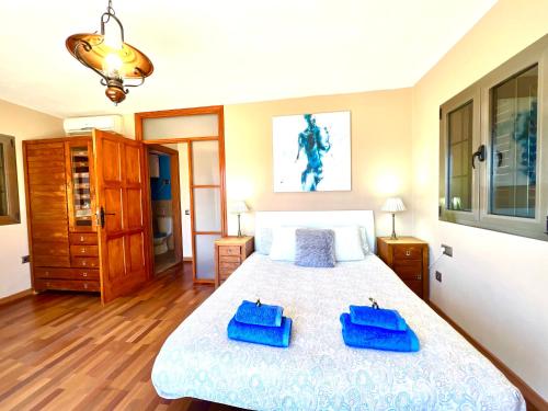 Un dormitorio con una cama con toallas azules. en La Higuerita de Tetir, en Tetir