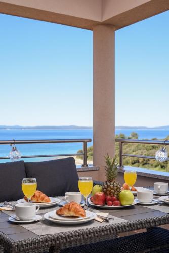 a table with food on it with a view of the ocean at Sunset Beach Suites in Kožino