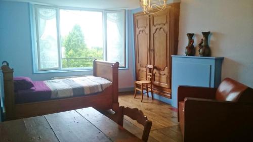 a bedroom with a bed and a window and a chair at Le gite andre dhotel 