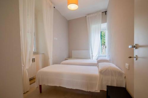 Duas camas num quarto com uma janela em CasaSmeraldo em Rio Marina
