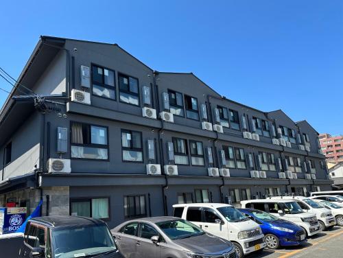 a large black building with cars parked in a parking lot at Miro Kyoto Nijo Hotel in Kyoto