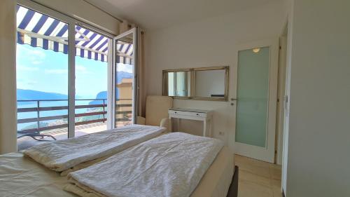 a bedroom with two beds and a large window at Casa Irene le Balze appartamento vista lago in Tremosine Sul Garda