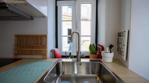 cocina con fregadero y ventana en The Alfama Apartment, en Lisboa