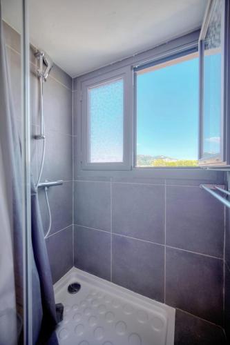La salle de bains est pourvue d'une douche et d'une fenêtre. dans l'établissement IMMOGROOM - 2 min from the Palais des Festival and the beaches - ac, à Cannes