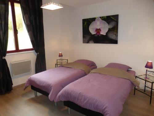 ein Schlafzimmer mit 2 Betten und einer Blume an der Wand in der Unterkunft La grange 