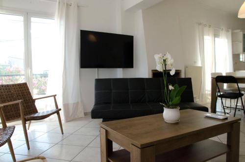 a living room with a black couch and a table at Eva's house in Kánithos