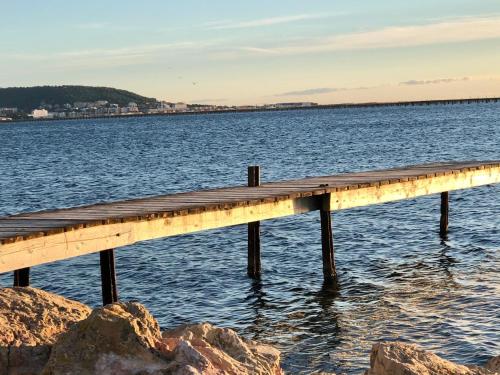 a wooden pier in the water with rocks at Grand studio indépendant in Paulhan