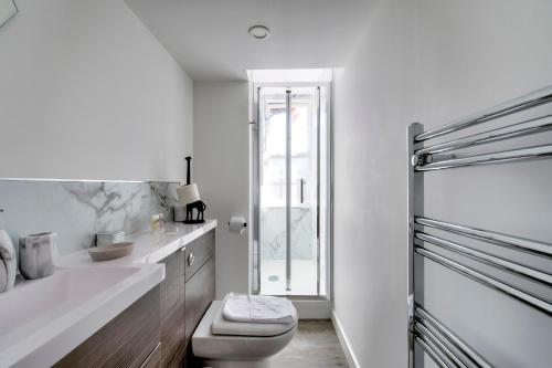 Baño blanco con aseo y lavamanos en Pass the Keys Modern 3 Bed Flat on the Historic Royal Mile, en Edimburgo