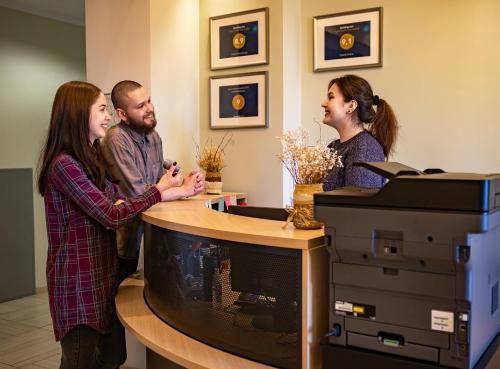 eine Gruppe von Menschen, die um einen Schreibtisch stehen in der Unterkunft Hotel Barentsburg in Barentsburg