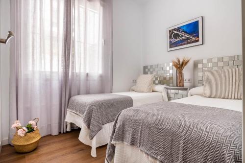 ein Hotelzimmer mit 2 Betten und einem Fenster in der Unterkunft Apartamento Leyendas de Becquer A4 in Sevilla