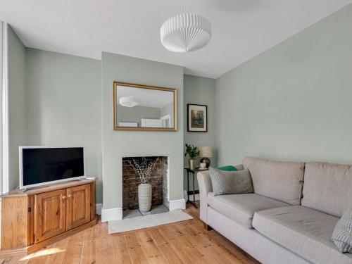 a living room with a couch and a television at Large Terraced Home In the City - Pass the Keys in Canterbury