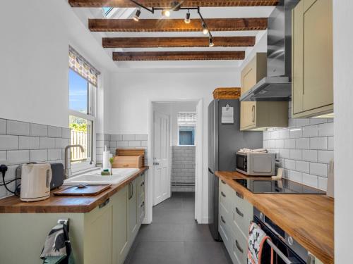 a kitchen with white cabinets and a counter top at Large Terraced Home In the City - Pass the Keys in Canterbury