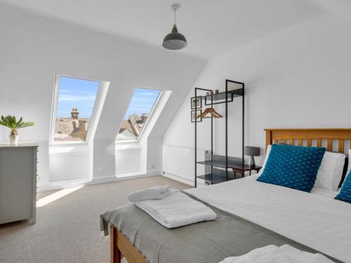um quarto com uma cama grande e 2 janelas em Pass the Keys Large Terraced Home In the City em Canterbury