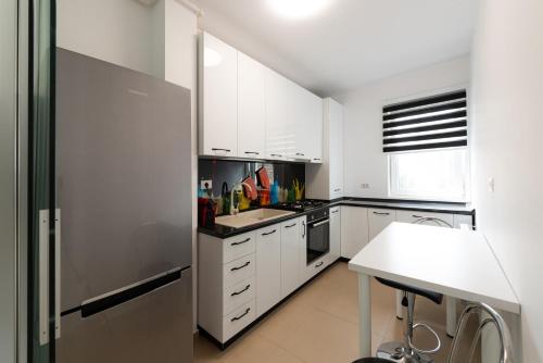 a kitchen with white cabinets and a stainless steel refrigerator at Eva in Bucharest