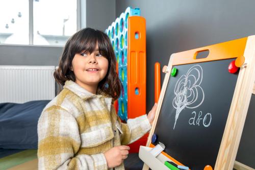 a little girl standing next to a chalkboard at a&o Copenhagen Sydhavn in Copenhagen