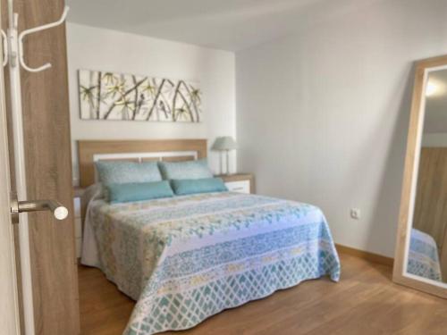 ein Schlafzimmer mit einem Bett mit blauen Kissen in der Unterkunft Cozy Apartament + BREAKFAST in La Esperanza