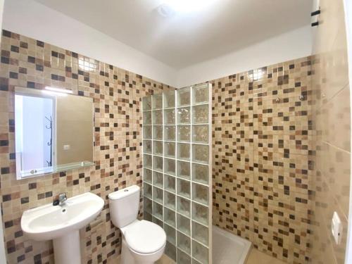 ein Badezimmer mit einem WC, einem Waschbecken und einem Spiegel in der Unterkunft Cozy Apartament + BREAKFAST in La Esperanza