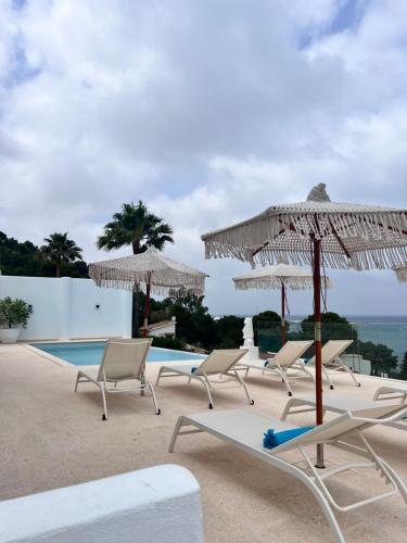 a group of chairs and umbrellas next to a pool at Atalaya Boutique in Denia