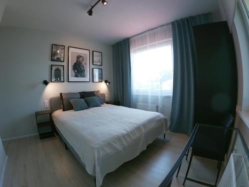 Un dormitorio con una cama grande y una ventana en Lapegle, en Alūksne