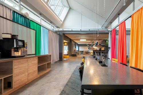 a long table in a room with colorful curtains at a&o Copenhagen Sydhavn in Copenhagen