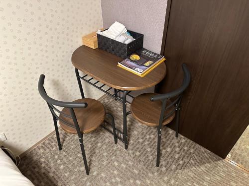 a small table with two chairs and a box of tissues at Miro Kyoto Nijo Hotel in Kyoto
