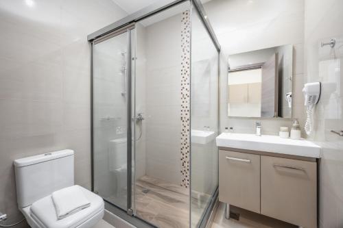 a bathroom with a shower and a toilet and a sink at Vice Hotel in Laganas