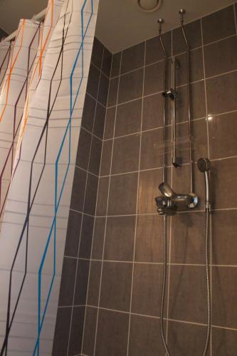 a shower with blue and orange lines on a tiled wall at SweetDream Guesthouse in Helsinki