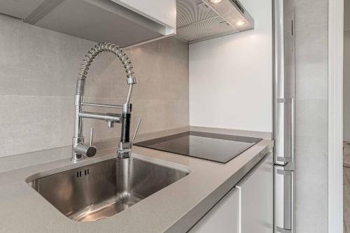 a kitchen with a stainless steel sink at Apartamentos Recaredo 7, Áticos con terraza in Seville